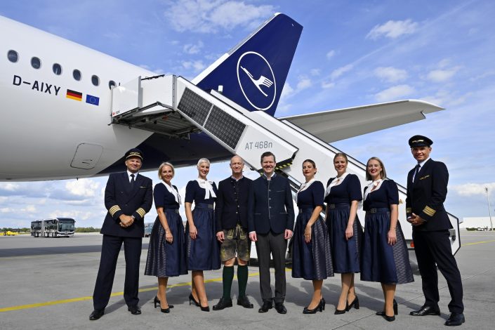 Flughafen München Oktoberfest mit Lufthansa Trachtencrew vor einem Flugzeug auf dem Vorfeld des Airports